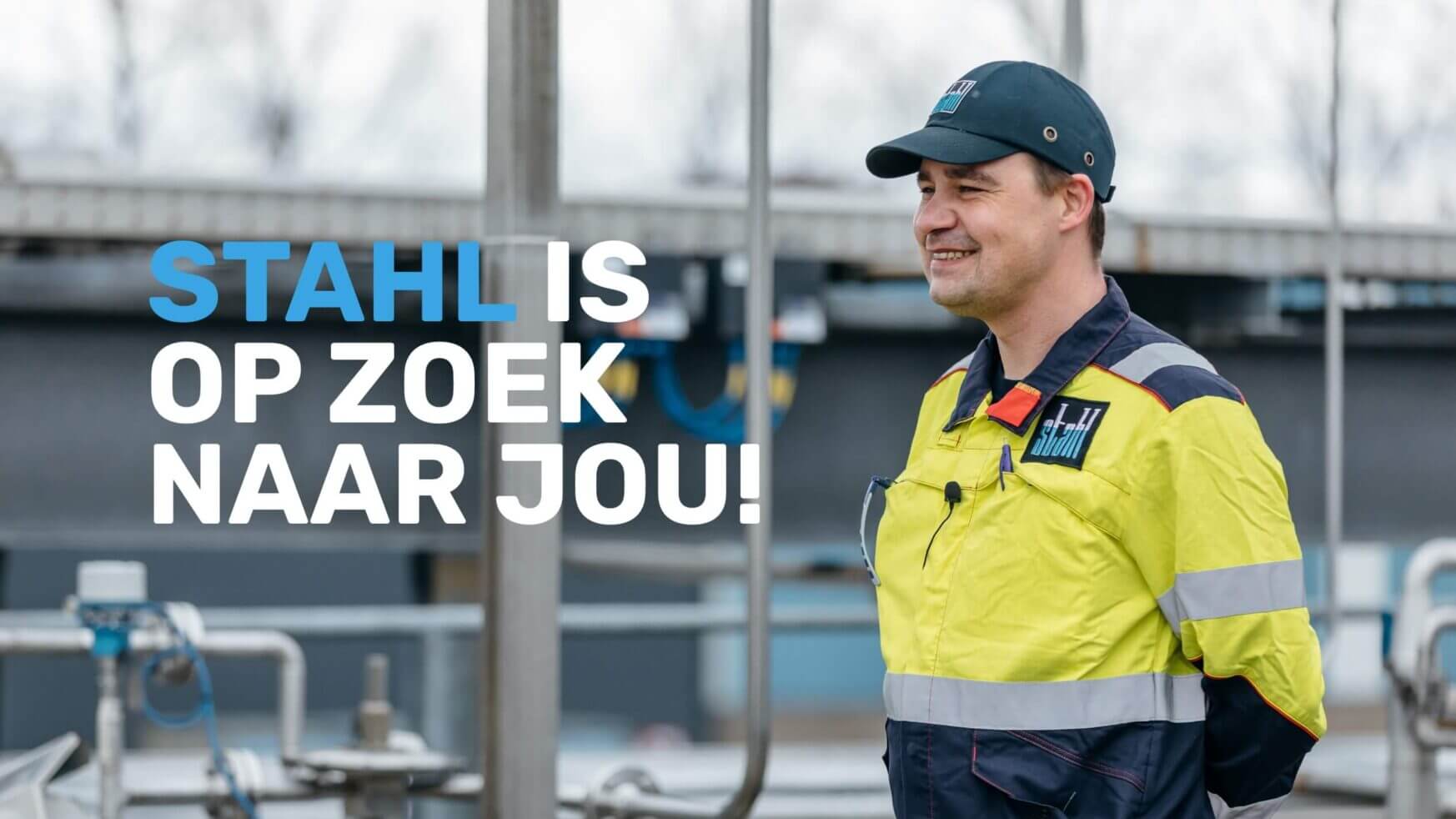 Arbeider in gele jas en pet aan de buitenkant, met tekst: "STAHL IS OP ZOEK NAAR JOU!.