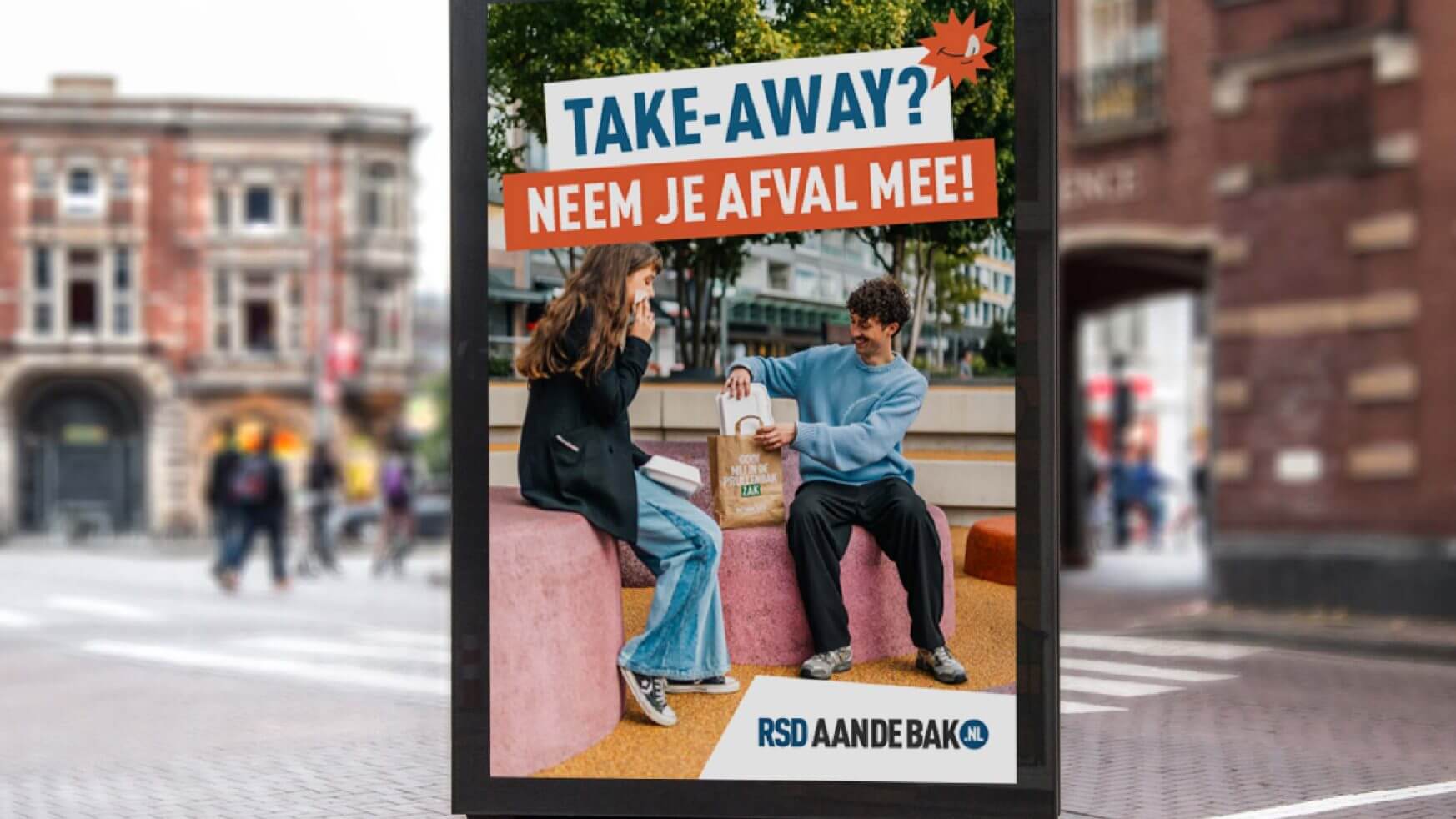 Twee mensen eten een afhaalmaaltijd op een bankje; op een bordje staat "Neem je afval mee! Neem je afval mee! RSD aan de bak!.