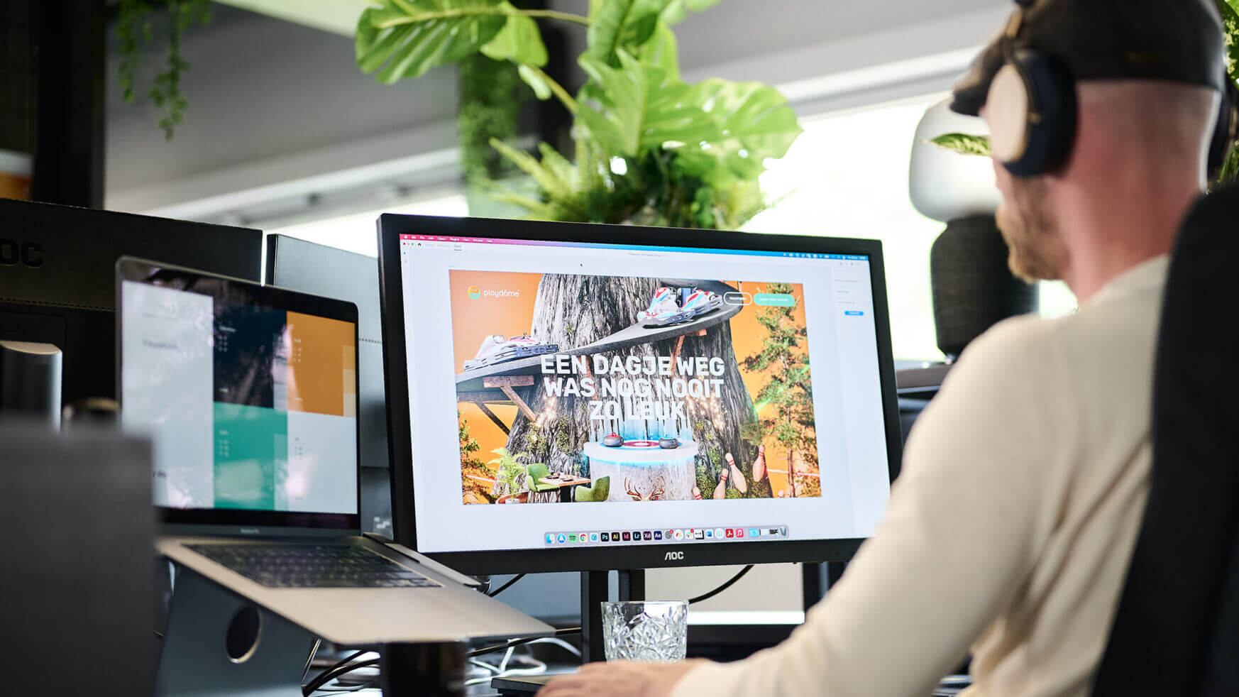 Met een koptelefoon op duiken ze in de levendige wereld van Playdome op een bureaublad, omringd door weelderige planten.
