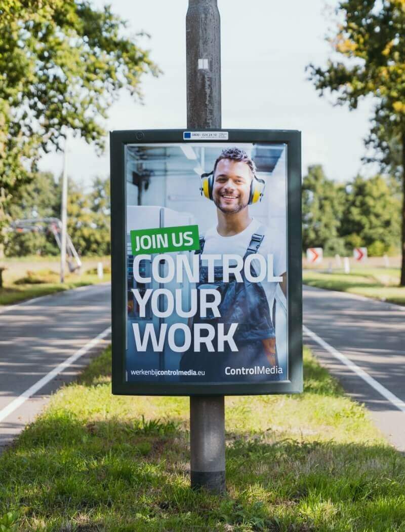 Straatnaambord: In de advertentie van ControlMedia is een lachende persoon met een koptelefoon te zien.