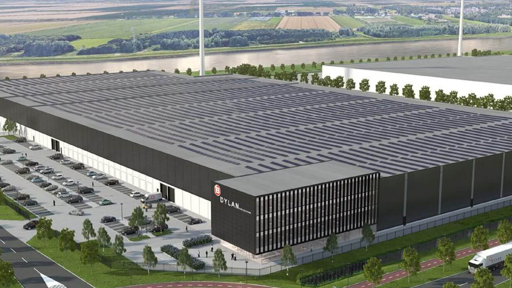 Het op zonne-energie werkende magazijn van Dylan Steel Solutions, te midden van groen en windturbines, van bovenaf vastgelegd.