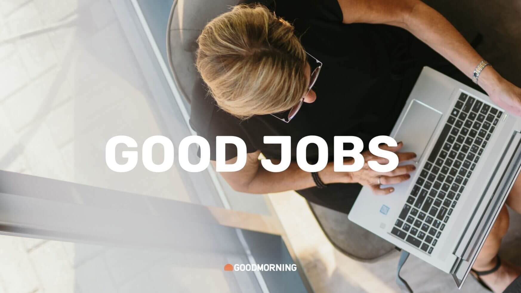 Bovenaanzicht van handen op een laptop, met op het scherm de tekst "GOED WERK".