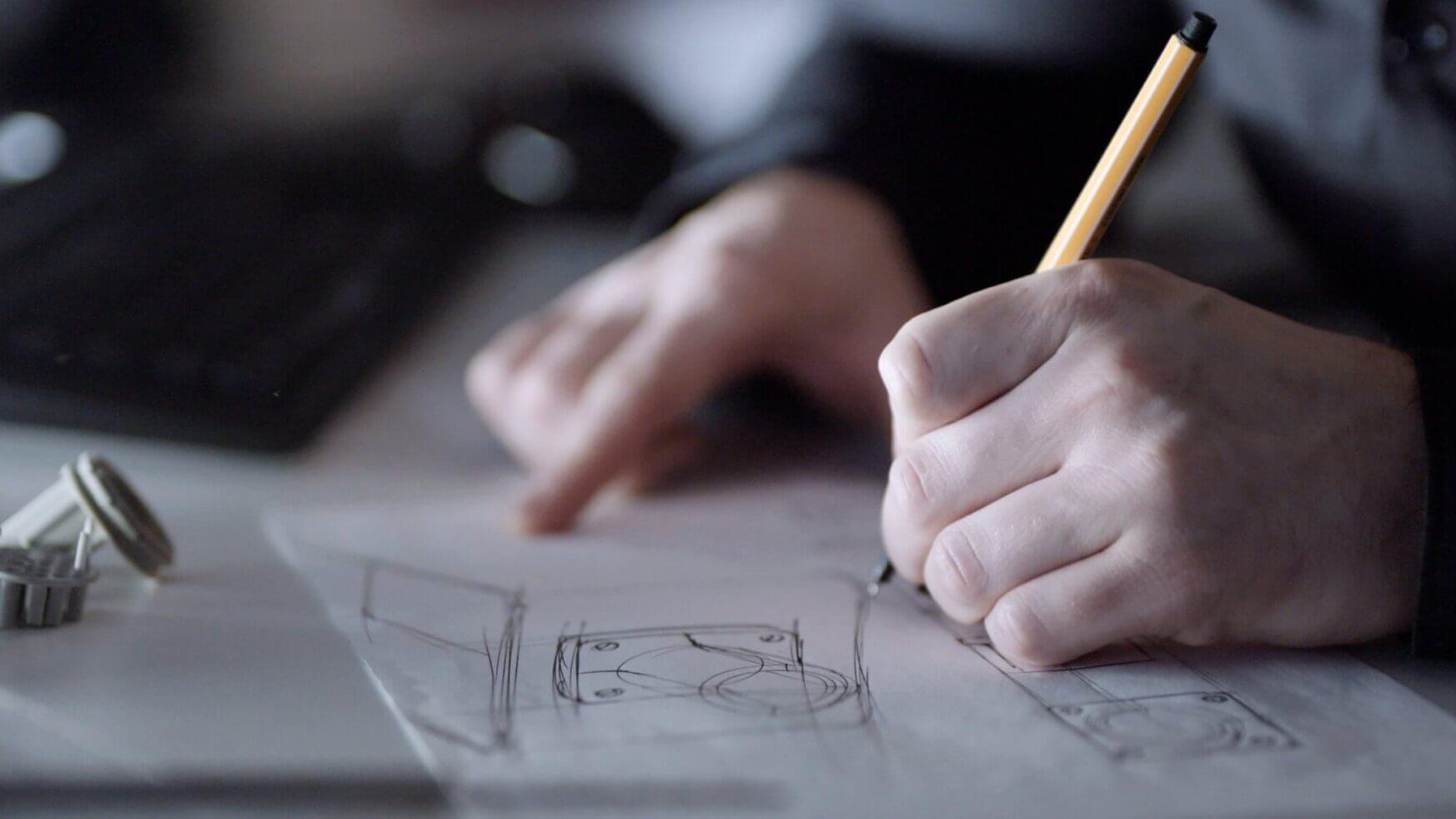 Met potlood worden mechanische ontwerpen gemaakt met behulp van het toetsenbord en onderdelen, de LUMINAID-lantaarn verlicht zachtjes tandwielen en schema's.