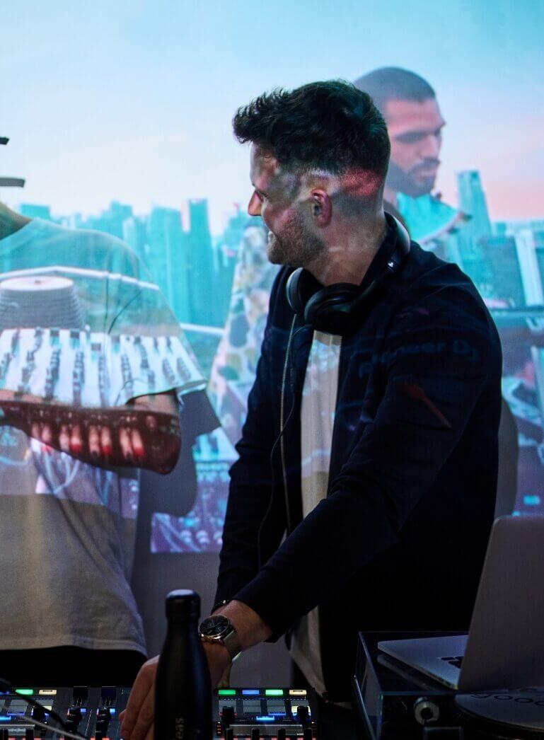 DJ mixt beats met de skyline van de stad op de achtergrond.