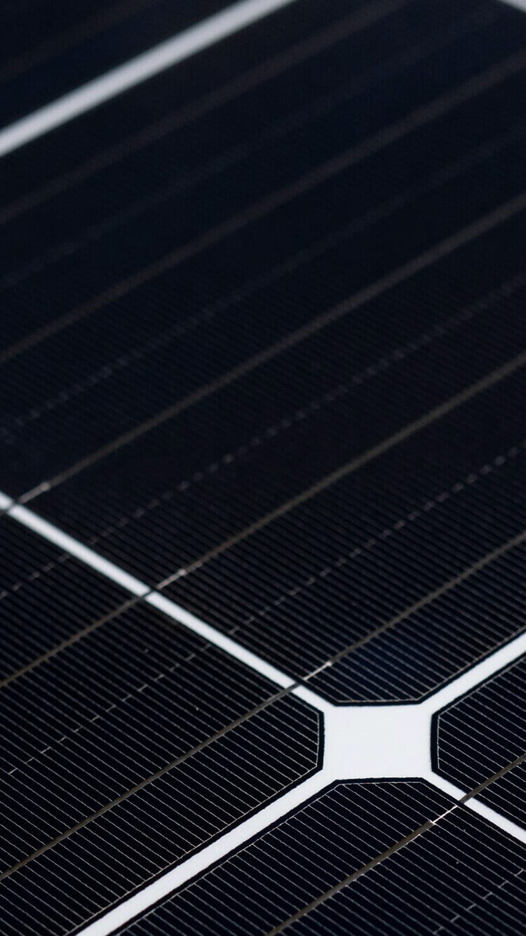 Close-up van YMX Euro Solar-paneel: donkere cellen, rasterlijnen, witte T-splitsing.