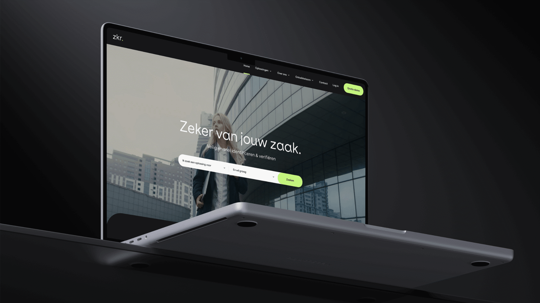 Een slanke laptop toont de homepage van een bedrijfssite met de Nederlandse uitdrukking "Zeker van jouw zaak".