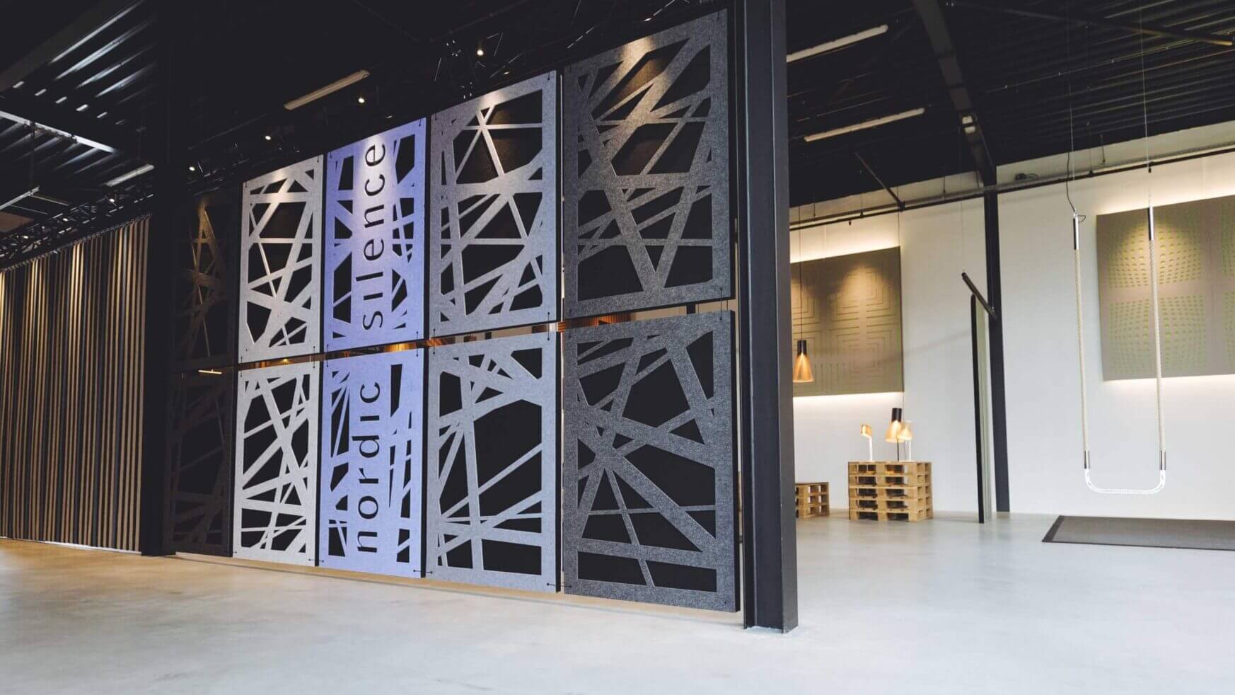 Ontdek een TunnelmaDesign-ruimte: geometrische muren, hoge plafonds en minimalistische inrichting creëren een open, moderne sfeer.