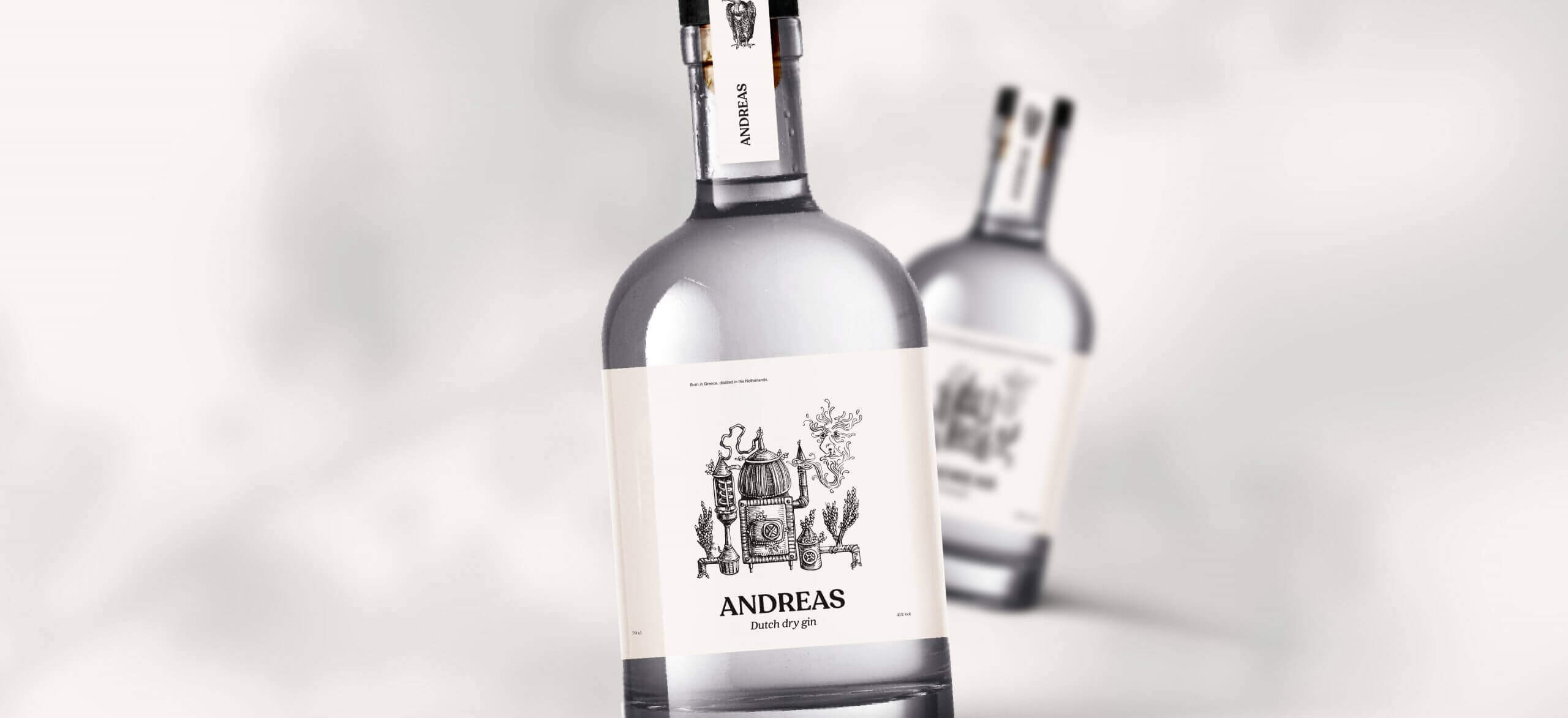 De doorzichtige fles van Andreas Dry Gin heeft een gedetailleerd etiket tegen een wazige achtergrond.
