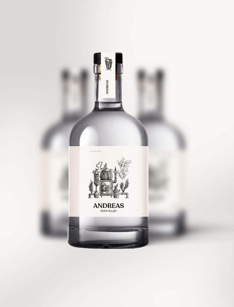 Close-up: heldere glazen fles met het opschrift "Andreas" met twee wazige flessen op de achtergrond.