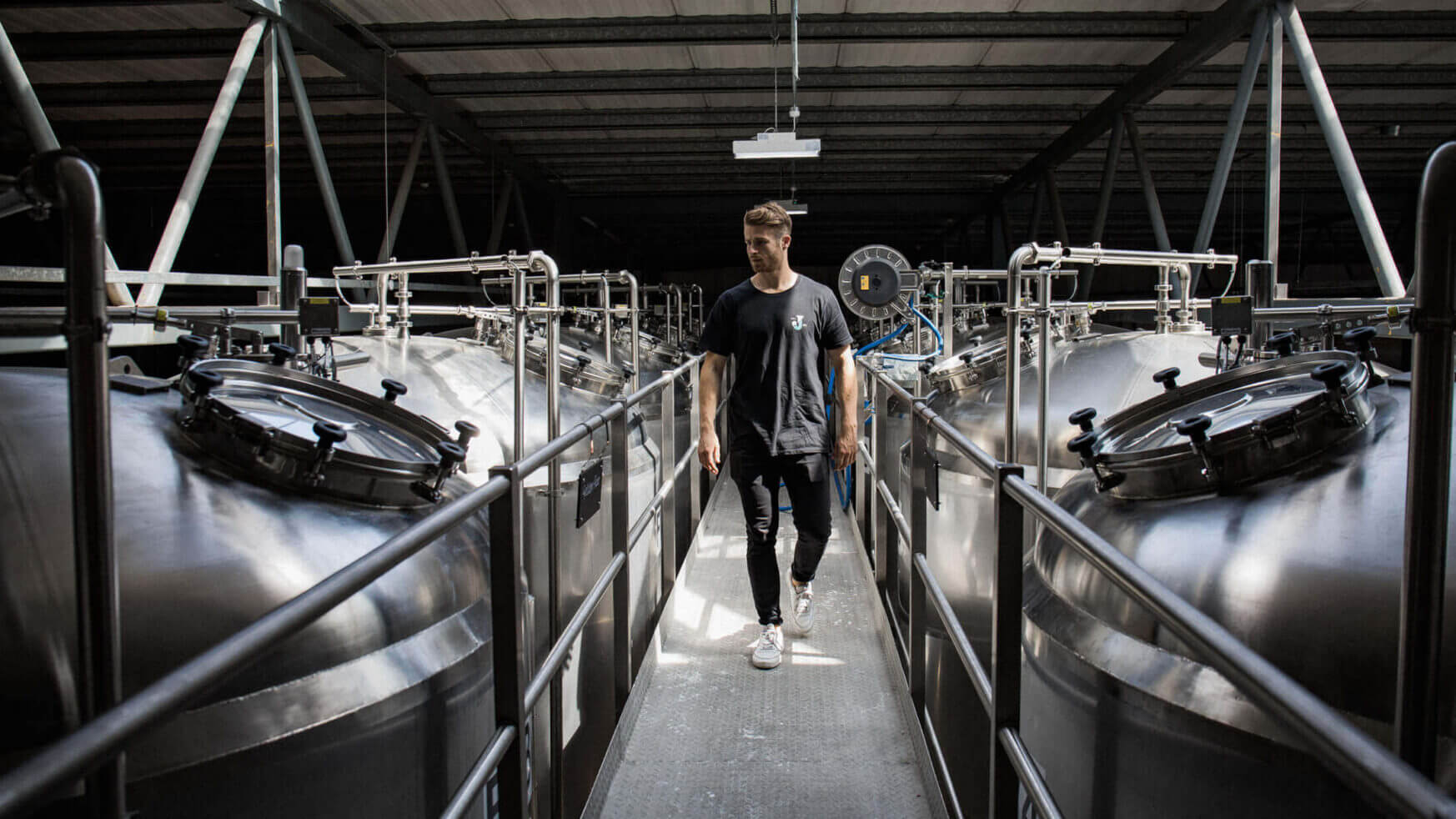 Er loopt iemand rond tussen de gigantische zilveren tanks van Jubel Beer.
