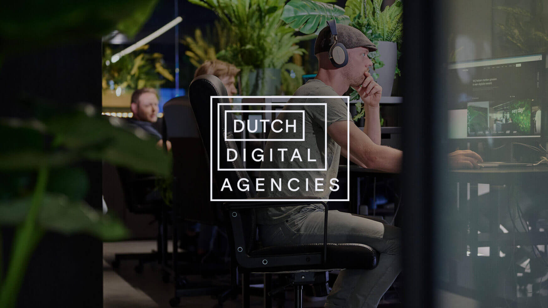 Modern kantoor, weelderige planten, mensen achter computers. Overlay: Nederlandse digitale bureaus.