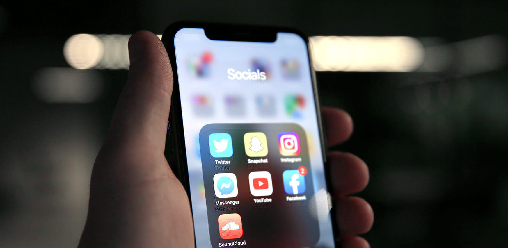 Hand vasthouden van een smartphone met social media-apps, ideaal voor het onder de knie krijgen van SEO- en SEA-strategieën.