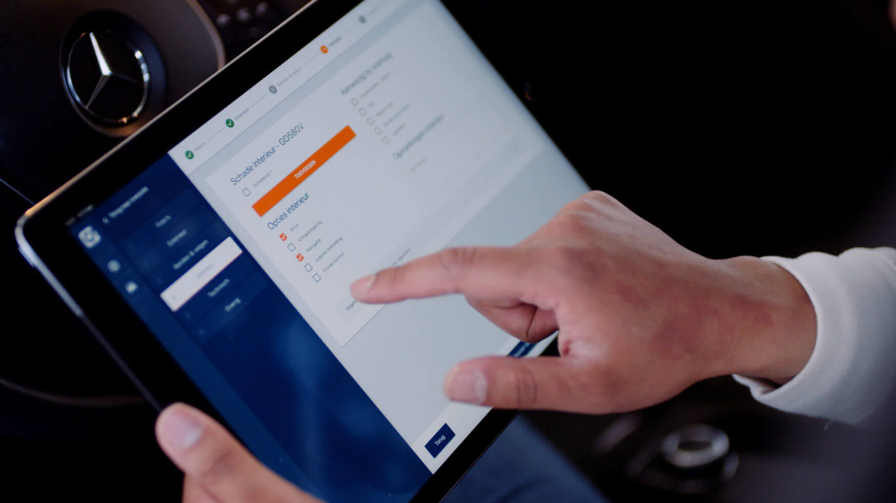 In de auto navigeert een gebruiker vakkundig op een tablet om instellingen te wijzigen. Zo combineert hij zijn liefde voor technologie met het verzamelen van auto's.