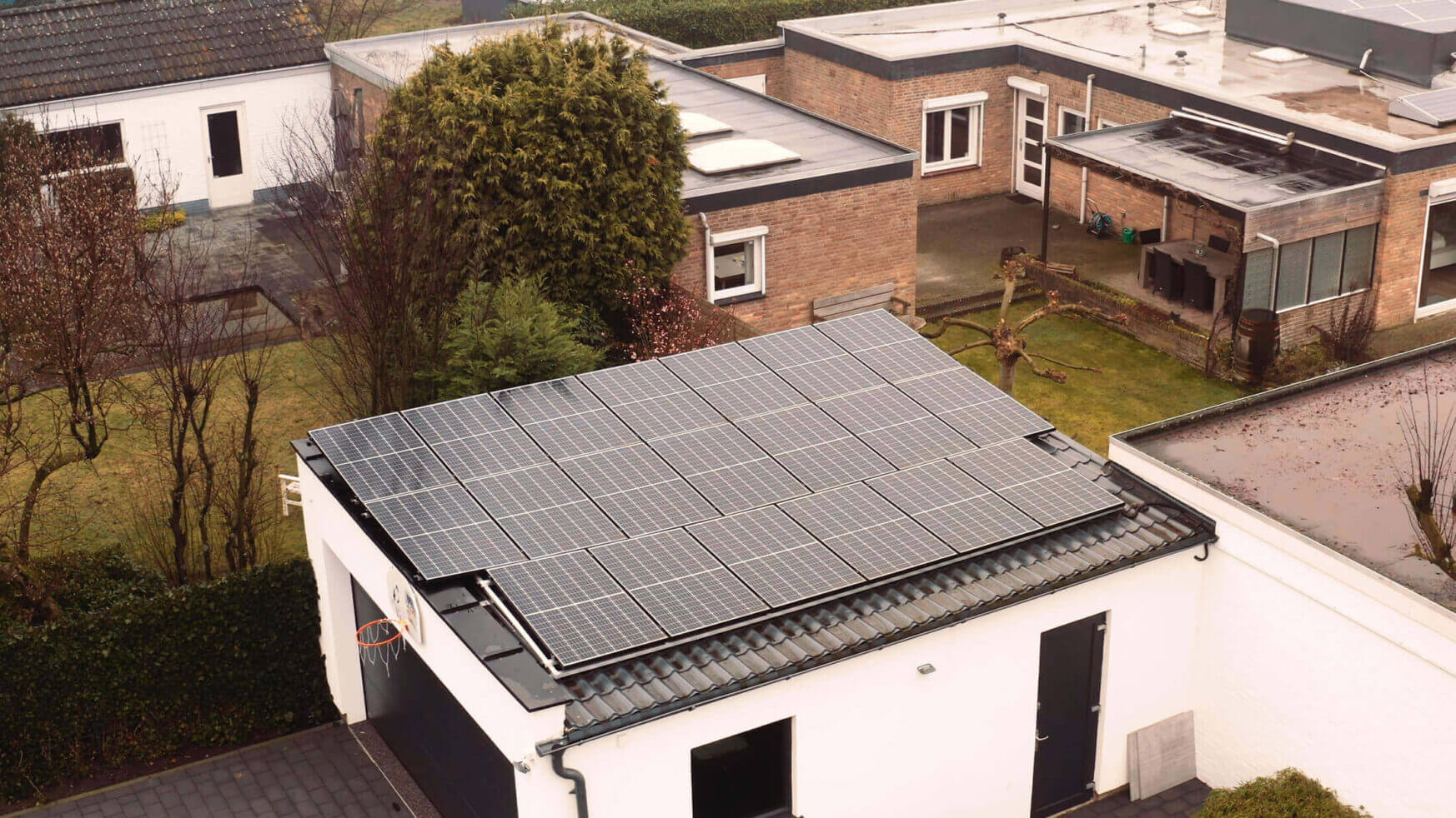 YMX Euro Solar panelen schitteren op een garage en versmelten met de bomen en verzorgde gazons in de buitenwijk.