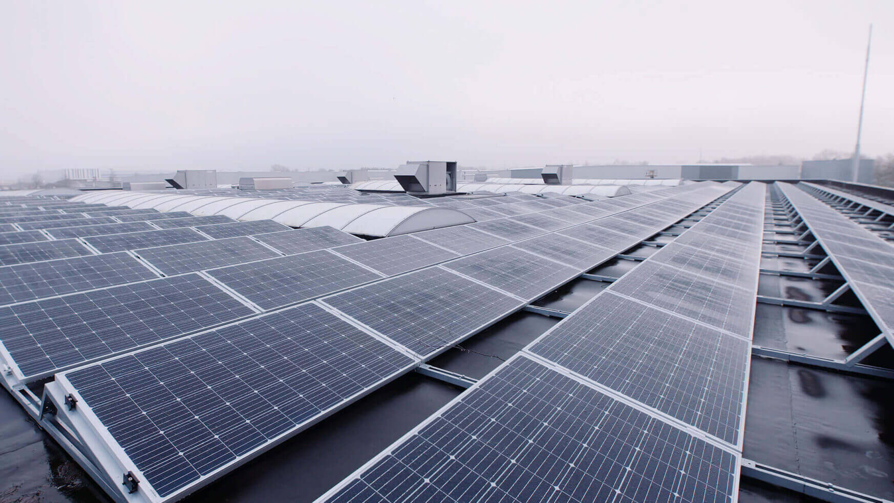 YMX Euro Solar-zonnepanelen zijn vakkundig aangebracht op een industrieel dak en benutten efficiënt energie, zelfs op bewolkte dagen.