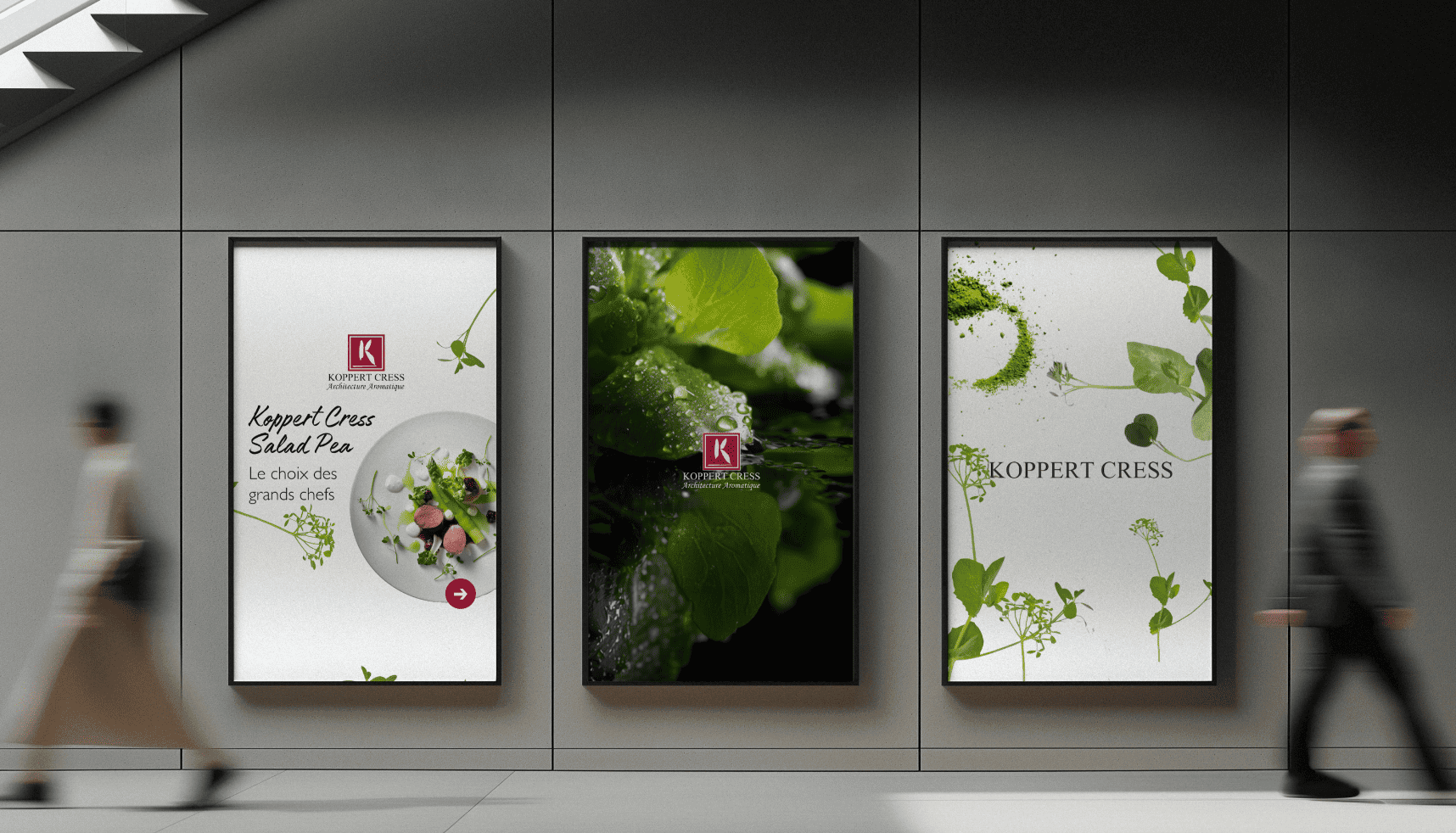 Drie Koppert Cress posters met kleurrijke kruiden hangen aan een muur in de hal terwijl mensen voorbij lopen in een strakke, moderne ruimte.