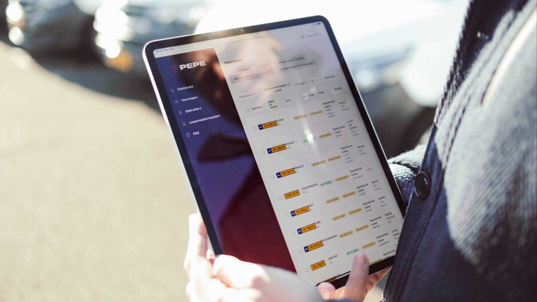 Iemand gebruikt buiten in het zonlicht een tablet en bekijkt een PEPE-dashboard met datadiagrammen.