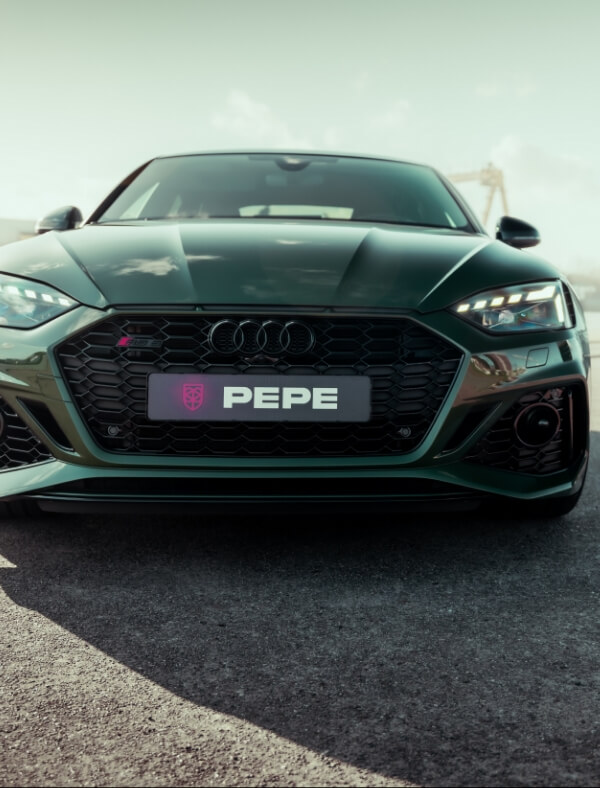 Donkergroene Audi met speciaal PEPE-kenteken, geparkeerd bij Koppert Cress. Vooraanzicht op de stoep.