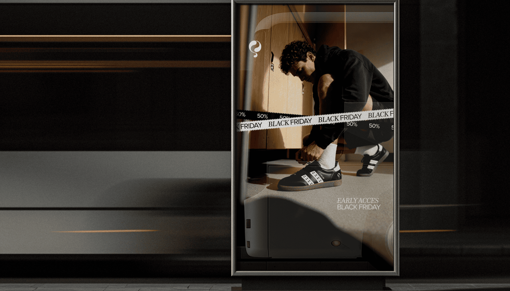 Advertentie bij bushalte met een man die zijn schoen strikt, Black Friday-verkoopband en tekst "Early Access Black Friday".