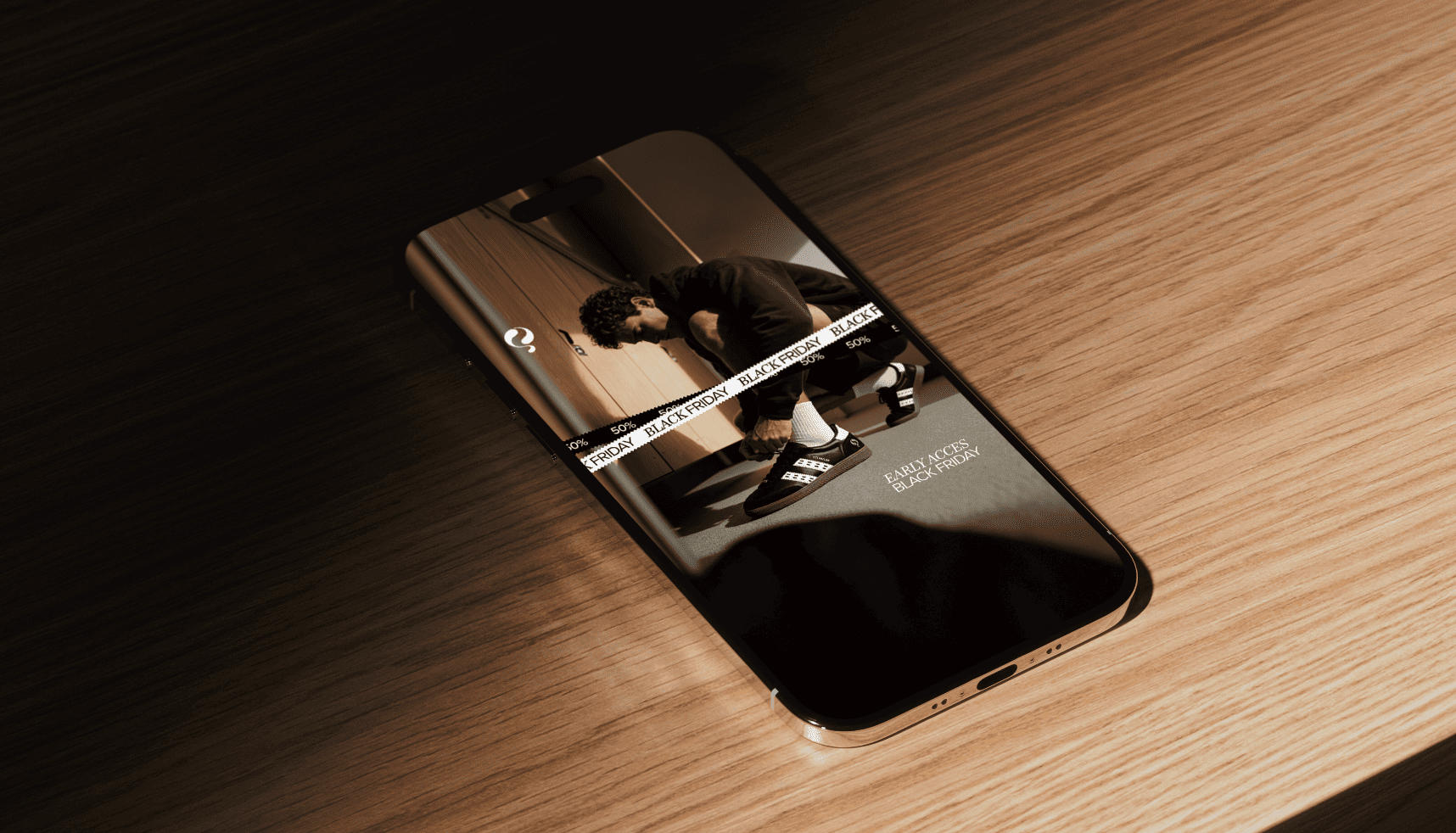 Smartphone op een houten tafel toont een fitness-app met een indoor workout.